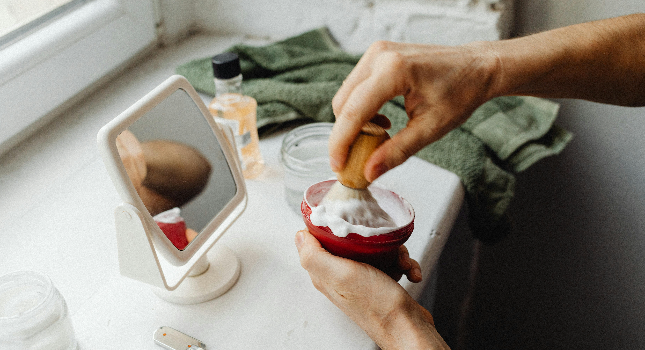 A man applying shaving foam to a shaving brush